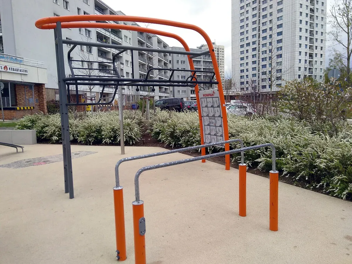 Outdoor calisthenics bars in a park, the kind of setup used for a beginner bodyweight workout