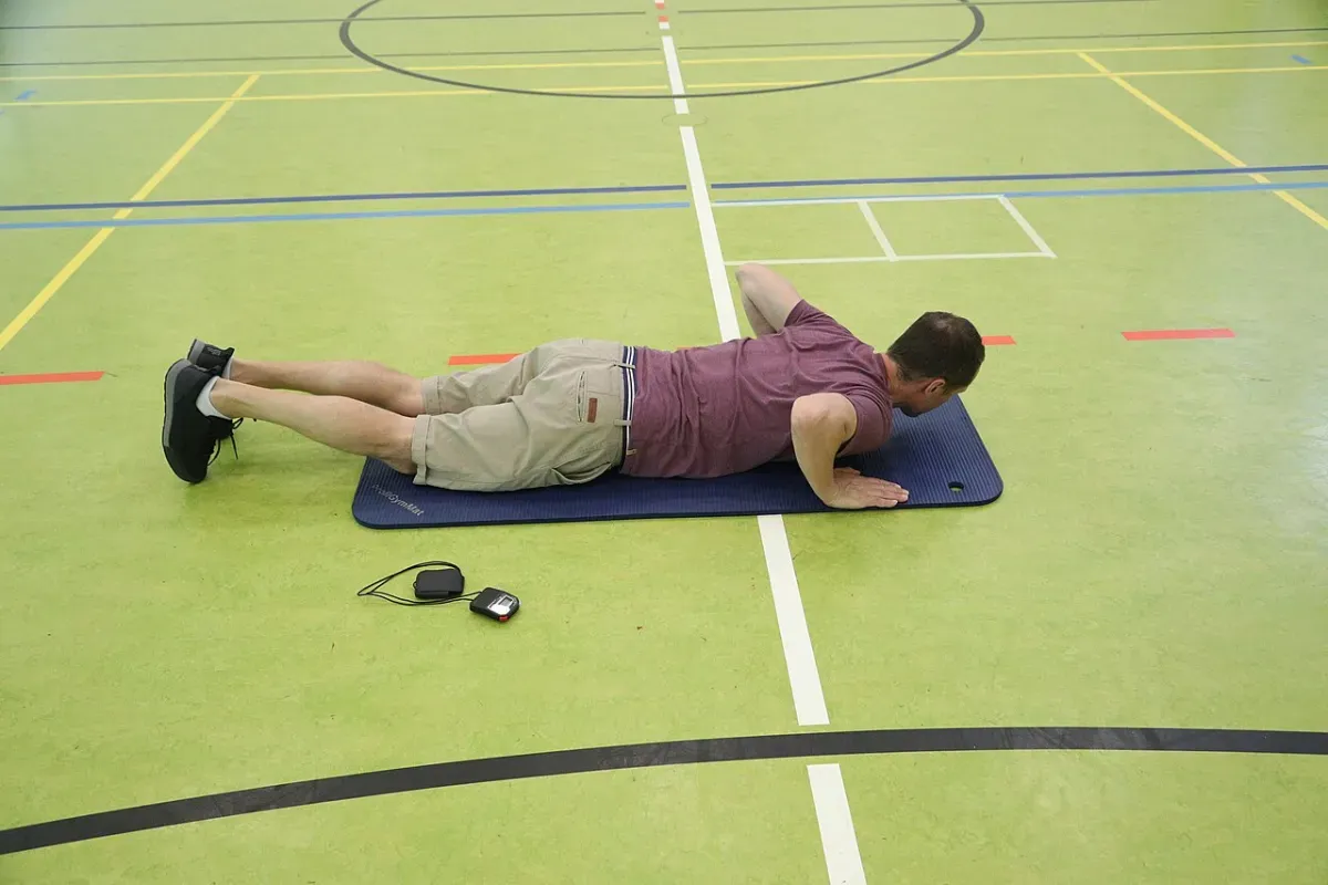 A beginner performing a bodyweight push-up on a mat with no equipment
