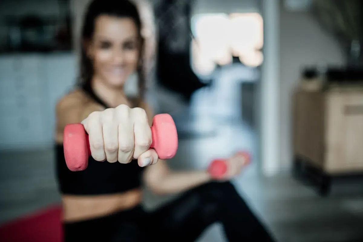 Allenamento dei glutei a casa con piccoli pesi su un tappetino
