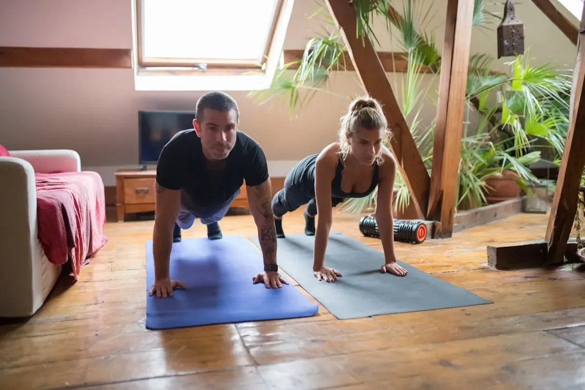 Two gym buddies training together and motivating each other at home