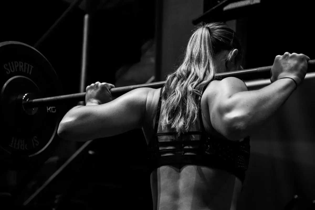 Person training with a barbell in a gym