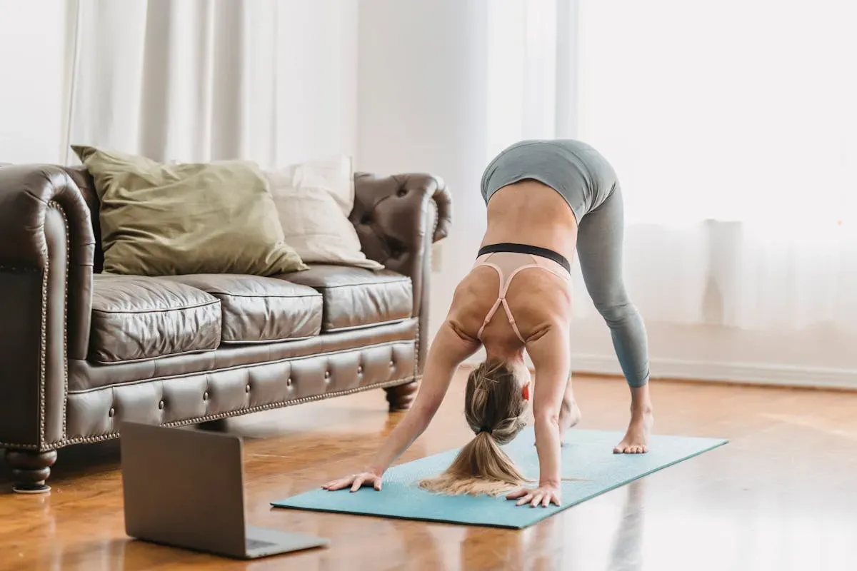 a woman staying motivated during a home workout, sitting on a mat checking her phone