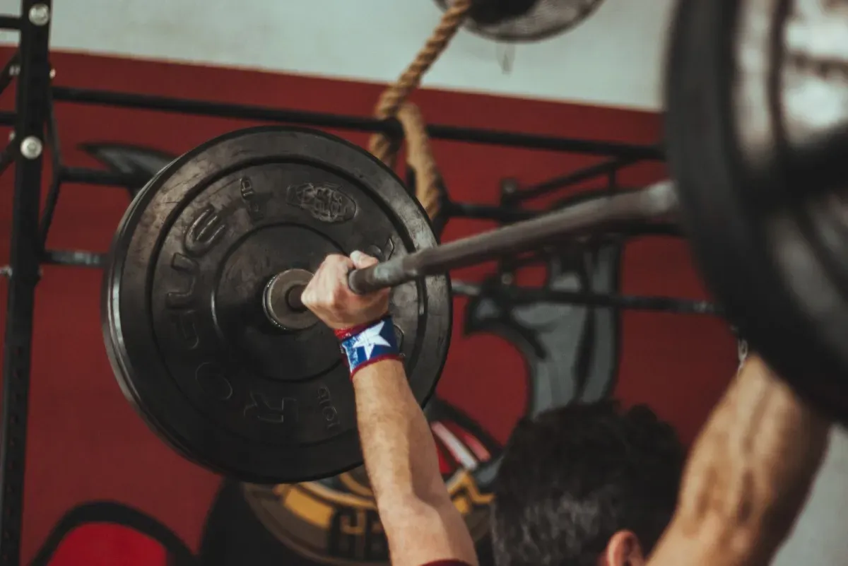 Athlete loading a barbell for a heavy lift, a scene that gym motivational quotes are made for
