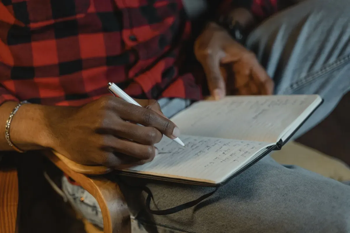 A person writing in a journal, a simple way to make gym motivational quotes stick as a daily cue