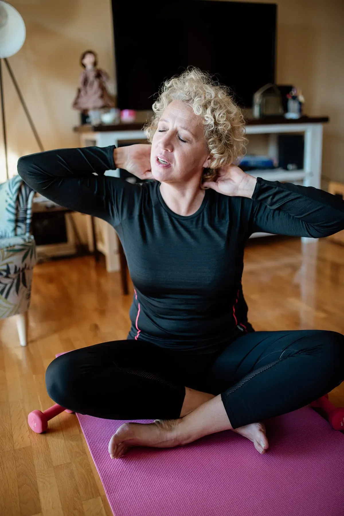 Woman doing a calm morning stretch routine on a mat at home