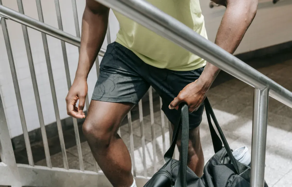 How to motivate yourself to go to the gym: man carrying a gym bag up a stairway