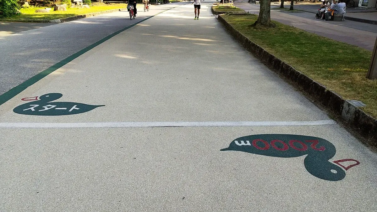 公園の周回コースの路面に描かれた「スタート」と「2000m」の距離表示（福岡市・大濠公園）