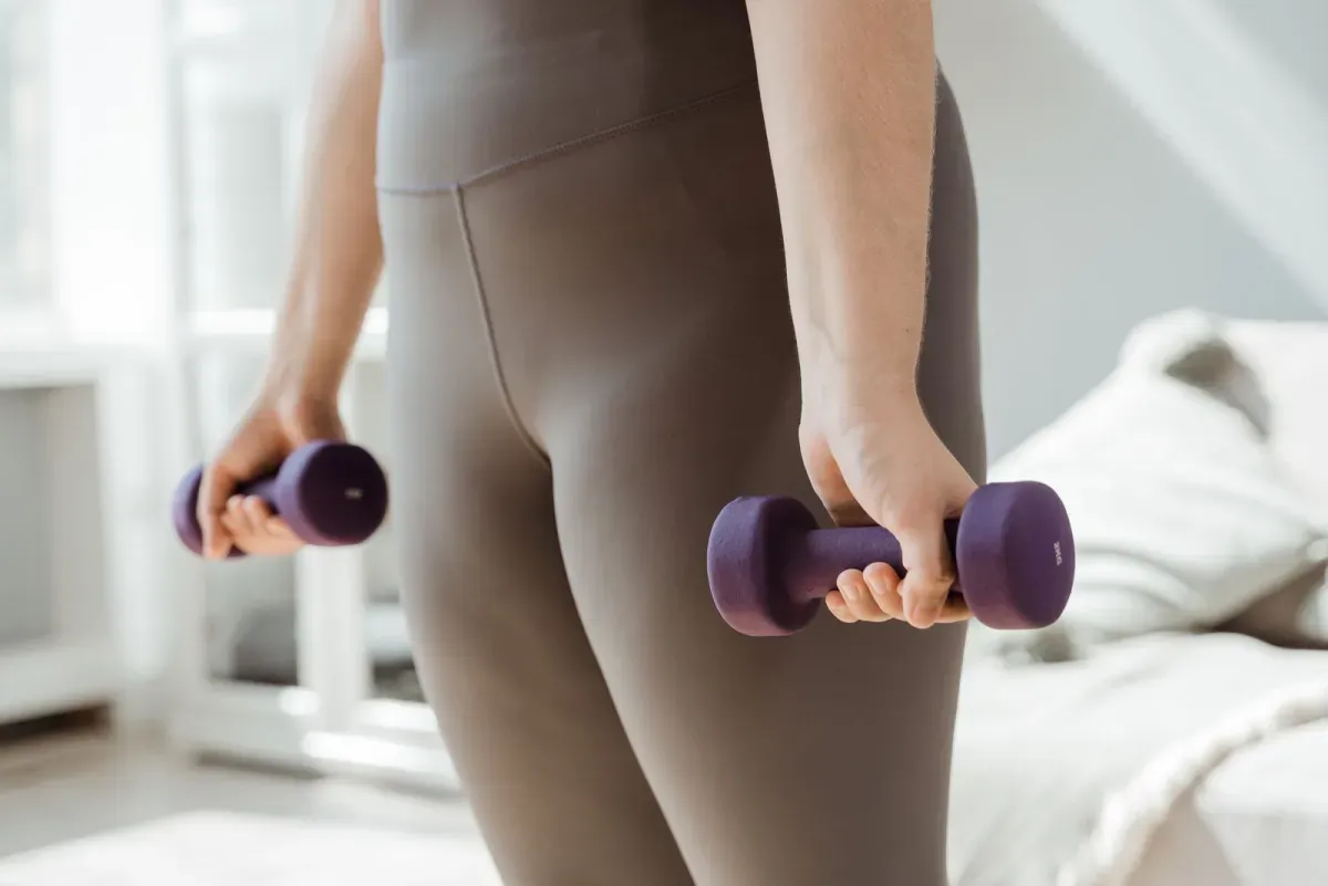 自宅でダンベルを使って筋トレをする様子