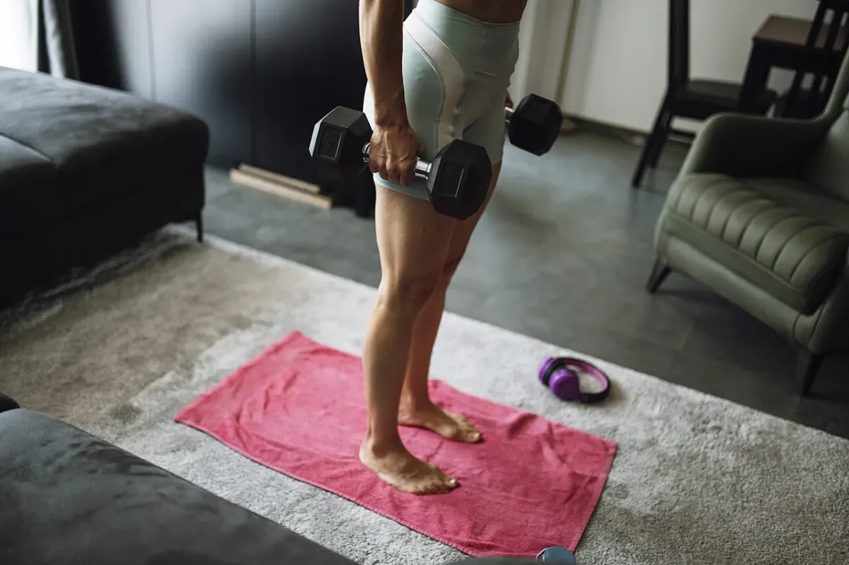 自宅でダンベルを持って筋トレをする様子