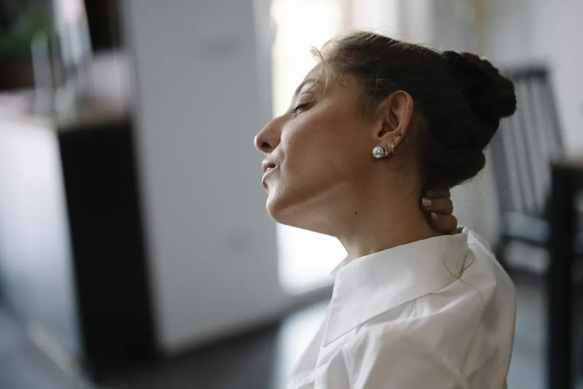 Head tilted back to open the front of the neck after hours at a desk