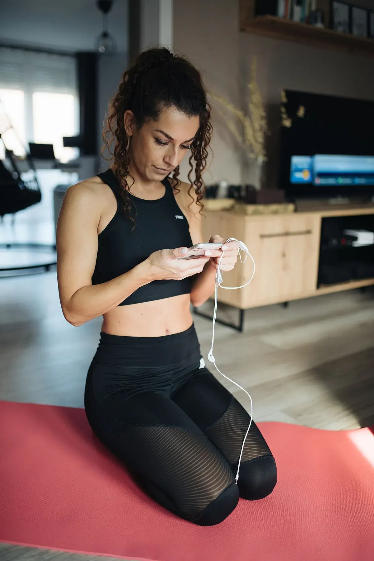Donna che organizza l'allenamento a casa con lo smartphone