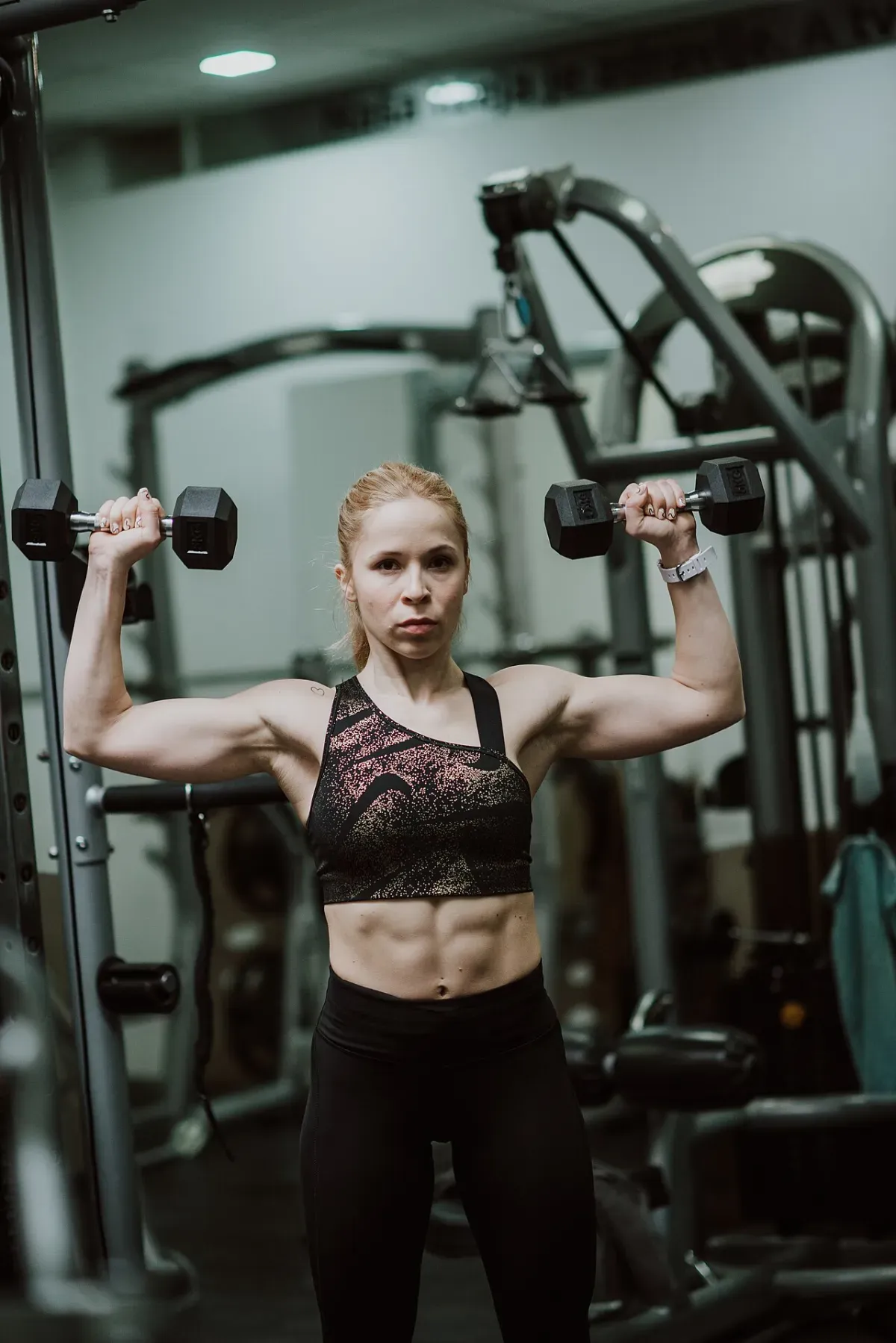Woman performing a shoulder press as part of a shoulder workout at home