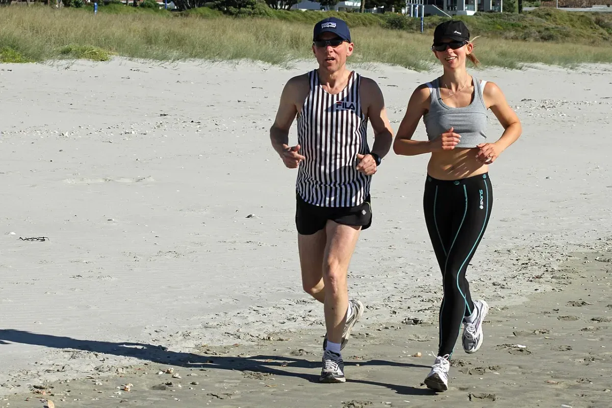 Two runners jogging easily side by side to warm up